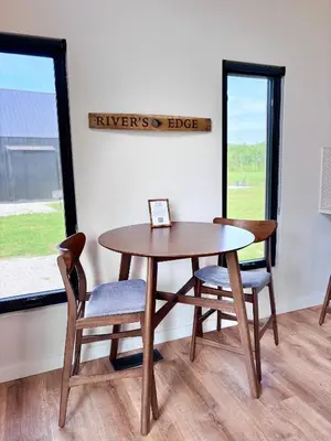 a table and chairs in a room with a window at River's Edge at Three Suns Cabins in Stanton