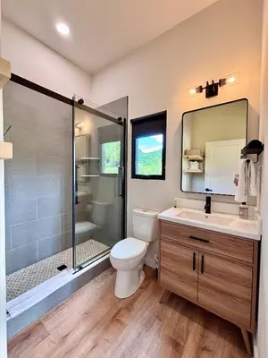 a bathroom with a toilet and a shower and a sink at Trail Tamer at Three Suns Cabins in Stanton