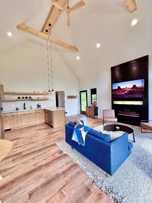 a living room with a blue couch and a flat screen tv at Trail Tamer at Three Suns Cabins in Stanton