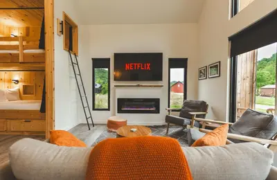 a living room with a couch and a tv at Moonrise Meadow at Three Suns Cabins in Stanton