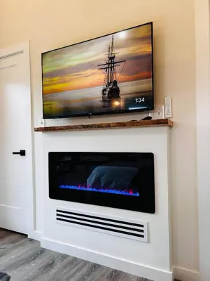 a fireplace with a tv on top of it at Moonrise Meadow at Three Suns Cabins in Stanton