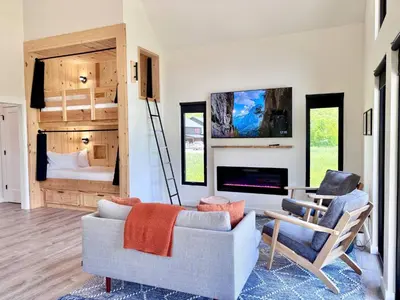 a living room with a couch and chairs and a bed at Moonrise Meadow at Three Suns Cabins in Stanton