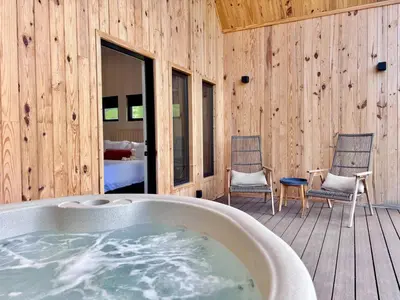 a bath tub in a room with two chairs at Moonrise Meadow at Three Suns Cabins in Stanton