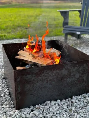 a fire pit with logs burning in it at Perfect Perch at Three Suns Cabins in Stanton