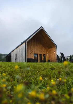 an old barn in a field of grass with flowers at River Rascal at Three Suns Cabins in Stanton