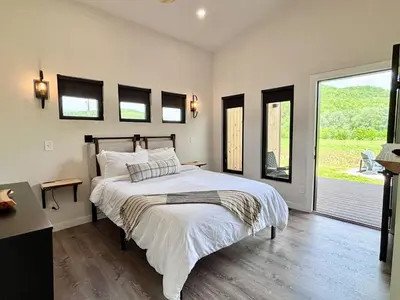 a bedroom with a large bed and a window at River Rascal at Three Suns Cabins in Stanton