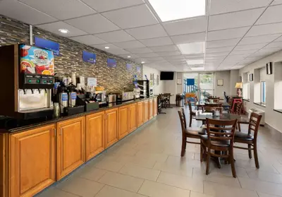 a restaurant with a bar and tables and chairs at Best Western Adena Inn in Chillicothe