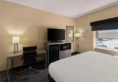 a hotel room with a bed and a desk and a tv at Best Western Adena Inn in Chillicothe