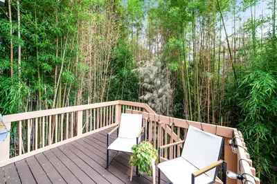 two chairs on a deck with trees in the background at Bamboo Retreat- Private Parking -New Reno -Central in Columbus