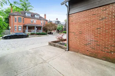 a brick building with a car parked next to a street at Bamboo Retreat- Private Parking -New Reno -Central in Columbus