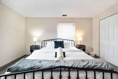a bedroom with a large white bed with two lamps at Bamboo Retreat- Private Parking -New Reno -Central in Columbus