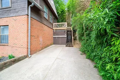 a house with a staircase next to a brick wall at Bamboo Retreat- Private Parking -New Reno -Central in Columbus