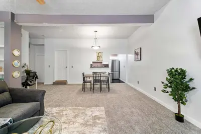 a living room with a couch and a table at Cozy Condo On Collins- Walk to High St /Dtown /OSU in Columbus