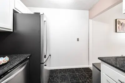 a kitchen with a stainless steel refrigerator at Cozy Condo On Collins- Walk to High St /Dtown /OSU in Columbus