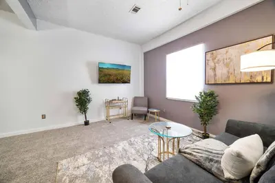 a living room with a couch and a table at Cozy Condo On Collins- Walk to High St /Dtown /OSU in Columbus