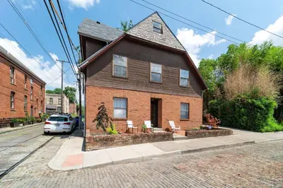 a house with two chairs in front of it at Cozy Condo On Collins- Walk to High St /Dtown /OSU in Columbus