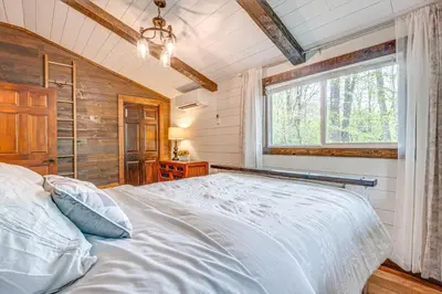a bedroom with a white bed and a window at Hocking Hills Social Distance Cabin with Hot Tub in Laurelville