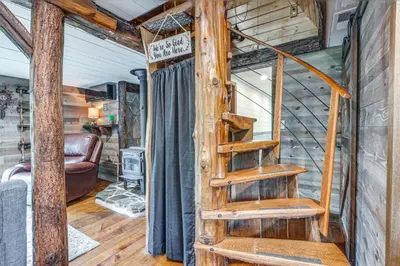 a spiral staircase in a tiny house at Hocking Hills Social Distance Cabin with Hot Tub in Laurelville