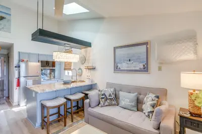 a living room with a couch and a kitchen at Boat Slip and Pool Access Oak Harbor Haven! in Oak Harbor