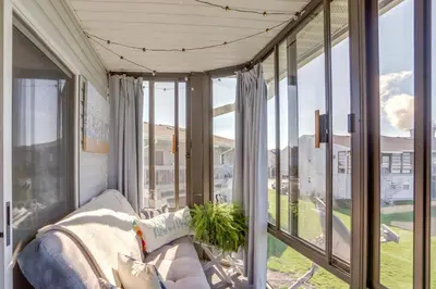 a porch with a couch and large glass windows at Boat Slip and Pool Access Oak Harbor Haven! in Oak Harbor