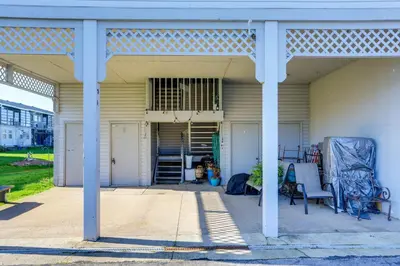 a covered porch with chairs and stairs on a house at Boat Slip and Pool Access Oak Harbor Haven! in Oak Harbor