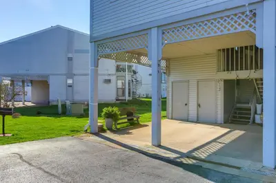a building with a porch and a bench in a yard at Boat Slip and Pool Access Oak Harbor Haven! in Oak Harbor