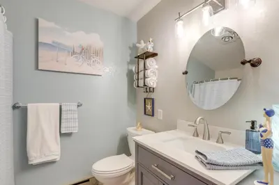 a bathroom with a sink and a toilet and a mirror at Boat Slip and Pool Access Oak Harbor Haven! in Oak Harbor