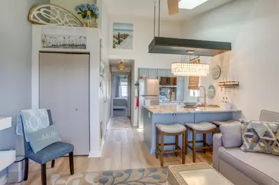 a living room with a couch and a kitchen at Boat Slip and Pool Access Oak Harbor Haven! in Oak Harbor