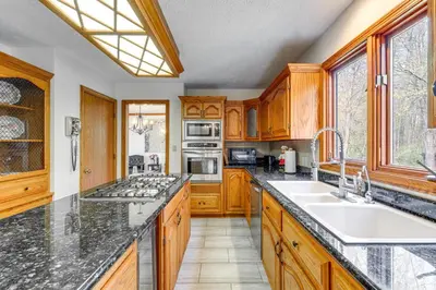 a kitchen with wooden cabinets and a large counter top at Bike, Fish, Golf and More Stately Tudor in Mogadore in Uniontown