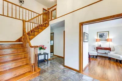 a hallway with a staircase and a living room at Bike, Fish, Golf and More Stately Tudor in Mogadore in Uniontown