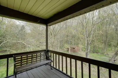 a screened in porch with a bench on the deck at Bike, Fish, Golf and More Stately Tudor in Mogadore in Uniontown