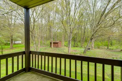 a screened porch with a view of the woods at Bike, Fish, Golf and More Stately Tudor in Mogadore in Uniontown