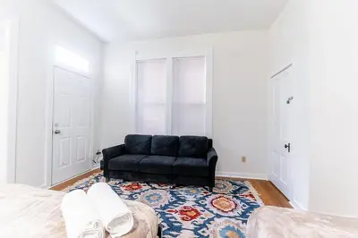 a living room with a black couch in a bedroom at Shine Retreat - Private parking - Newly Reno - OSU in Columbus