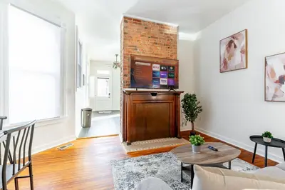 a living room with a television and a brick wall at Shine Retreat - Private parking - Newly Reno - OSU in Columbus
