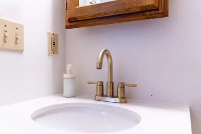 a bathroom sink with a gold faucet at Shine Retreat - Private parking - Newly Reno - OSU in Columbus