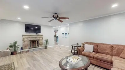 a living room with a couch and a fireplace at Sideline Sanctuary: Cozy Nights, Game Day Lights in Canton
