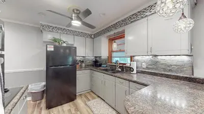 a kitchen with white cabinets and a stainless steel refrigerator at Sideline Sanctuary: Cozy Nights, Game Day Lights in Canton
