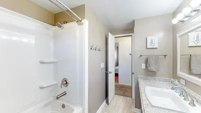 a white bathroom with a tub and a sink at The Blitz House-Where Legends Unwind in Canton