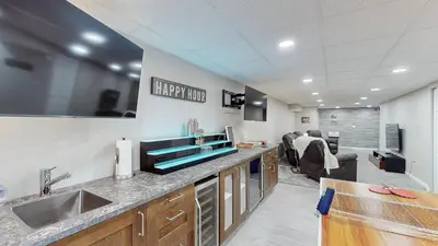 a kitchen with a sink and a living room at The Blitz House-Where Legends Unwind in Canton