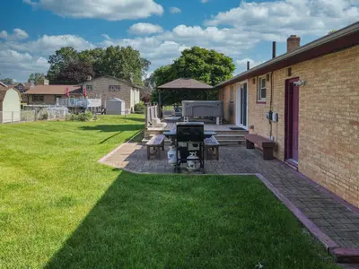 a backyard with a ping pong table and benches at The Blitz House-Where Legends Unwind in Canton