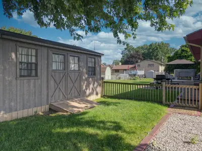 a storage shed with a fence and a yard at The Blitz House-Where Legends Unwind in Canton