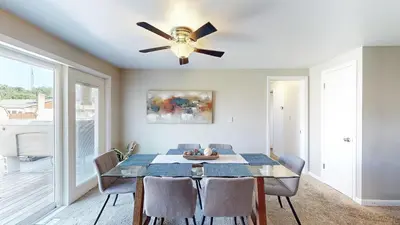 a dining room with a table and a ceiling fan at The Blitz House-Where Legends Unwind in Canton
