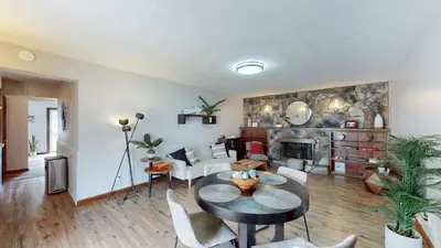 a living room with a table and a fireplace at Snap, Set, Stay-Game Day Comfort Near It All in Canton