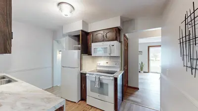 a kitchen with white appliances and wooden cabinets at Snap, Set, Stay-Game Day Comfort Near It All in Canton