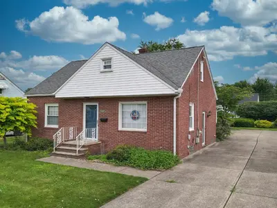 a red brick house with a porch and a driveway at Snap, Set, Stay-Game Day Comfort Near It All in Canton