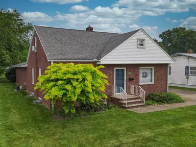 a red brick house with a tree in front of it at Snap, Set, Stay-Game Day Comfort Near It All in Canton