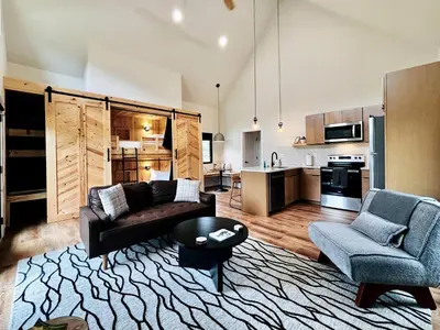 a living room with a couch and chairs and a kitchen at Three Suns Full Rental | 8 Cabins | Views | River in Stanton