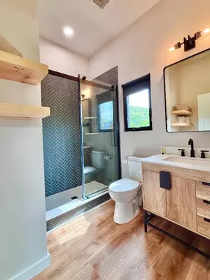 a bathroom with a shower and a toilet and a sink at Three Suns Full Rental | 8 Cabins | Views | River in Stanton