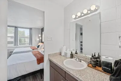 a bathroom with a bed and a sink with a mirror at Modern Stay Comfort-Free Parking in Cincinnati
