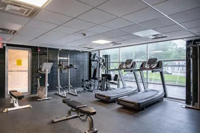 a gym with treadmills and machines in a room at Modern Stay Comfort-Free Parking in Cincinnati